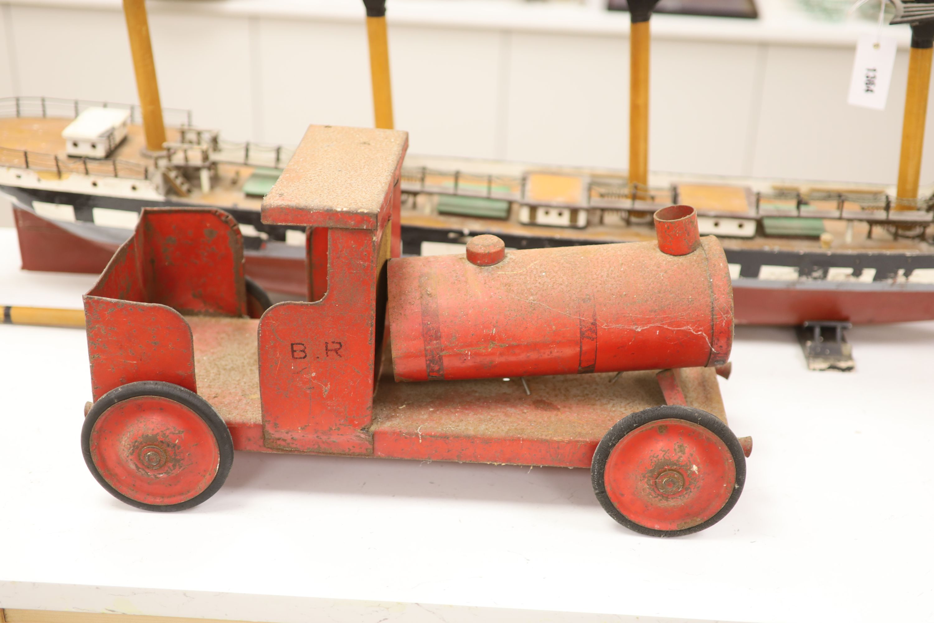 A scratch built primitive model of a cutter and an enamelled metal model of a locomotive, longest 137cm